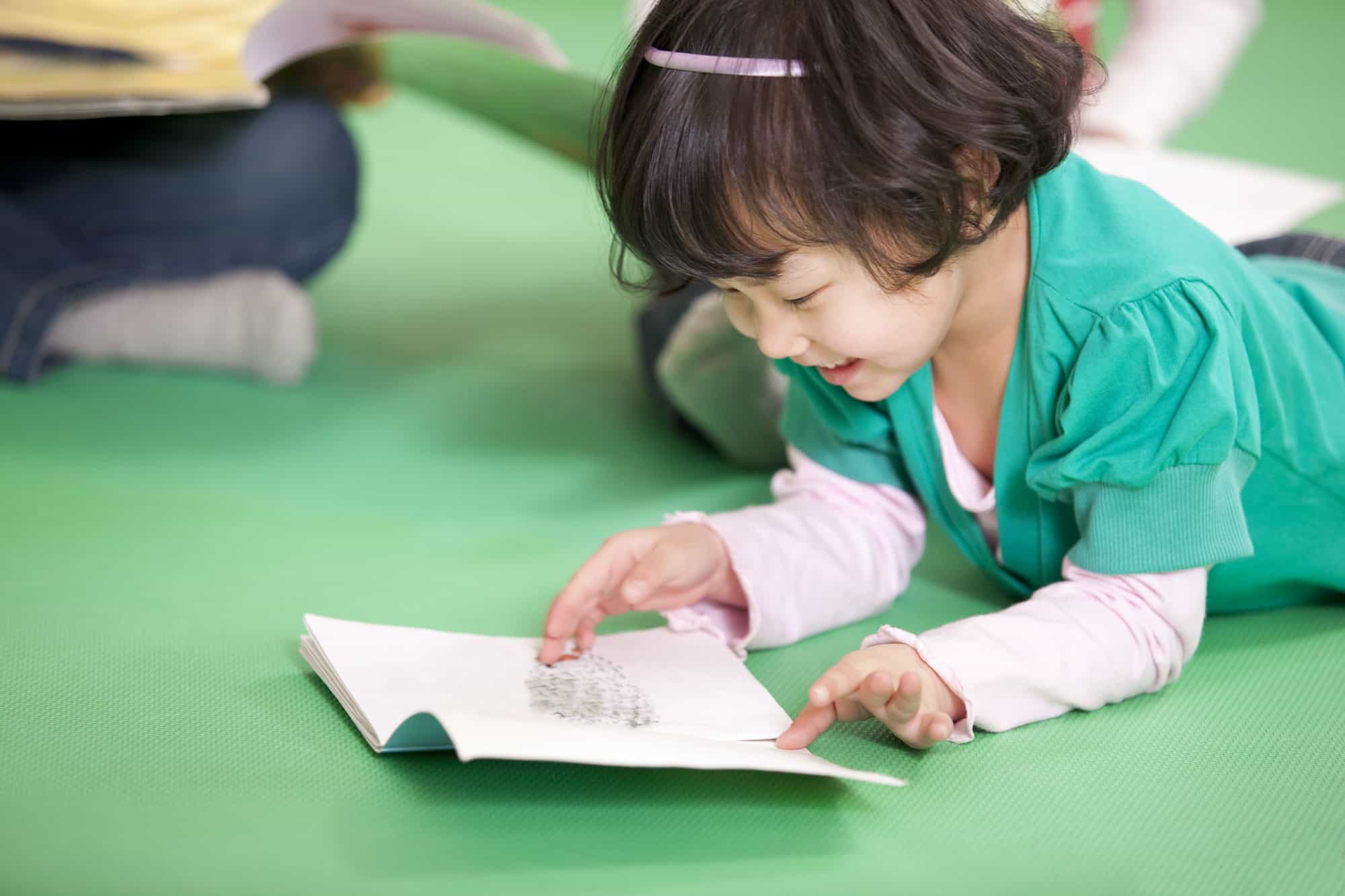 Cute little girl reading book