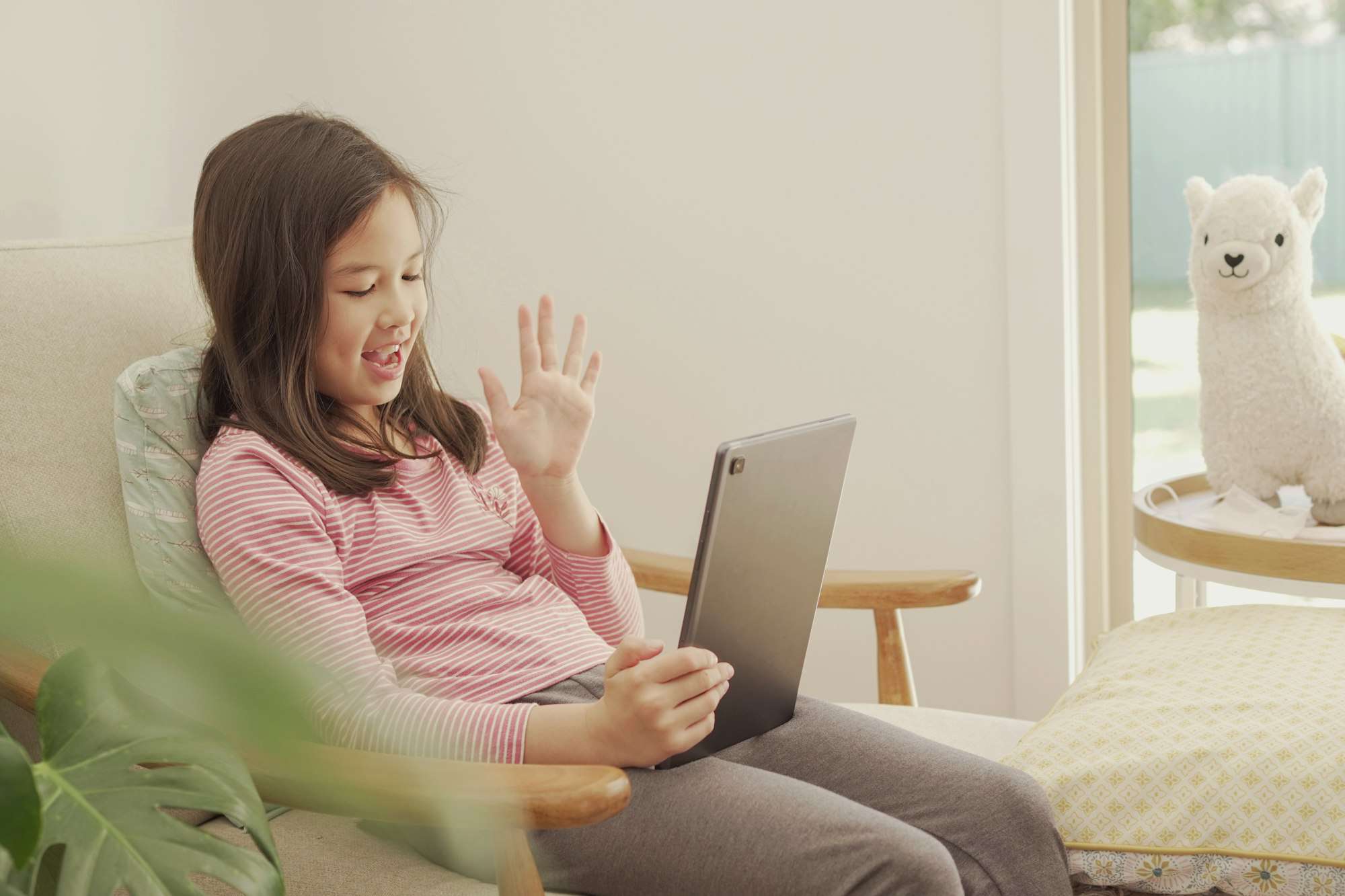 Mixed Asian girl making video calling with digital tablet at home, remotely learning